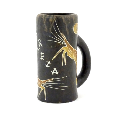 79 - A Spanish studio pottery beer tankard with prawn decoration and titled Cerveza. Marked Nalda under. ... 