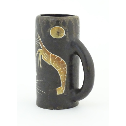 79 - A Spanish studio pottery beer tankard with prawn decoration and titled Cerveza. Marked Nalda under. ... 