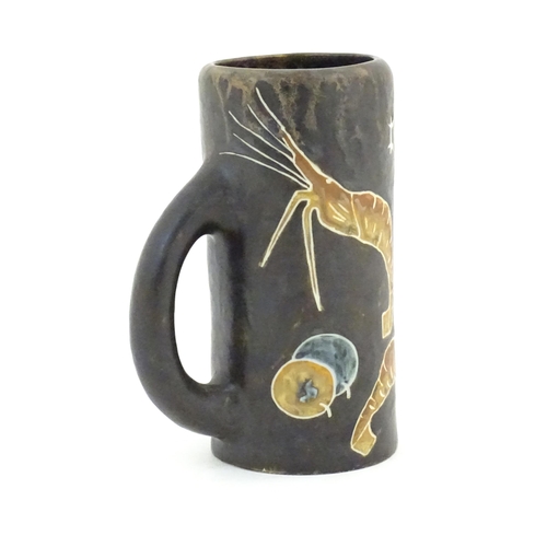 79 - A Spanish studio pottery beer tankard with prawn decoration and titled Cerveza. Marked Nalda under. ... 