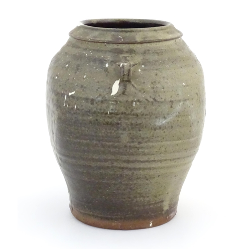 81 - A studio pottery vase with twin loop handles and drip glaze. Marked under handle C H. Approx. 9