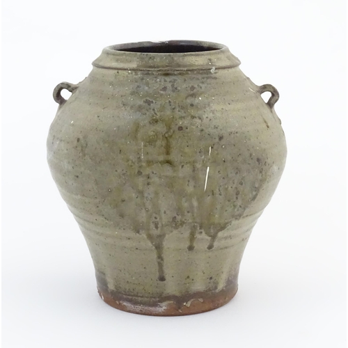 81 - A studio pottery vase with twin loop handles and drip glaze. Marked under handle C H. Approx. 9