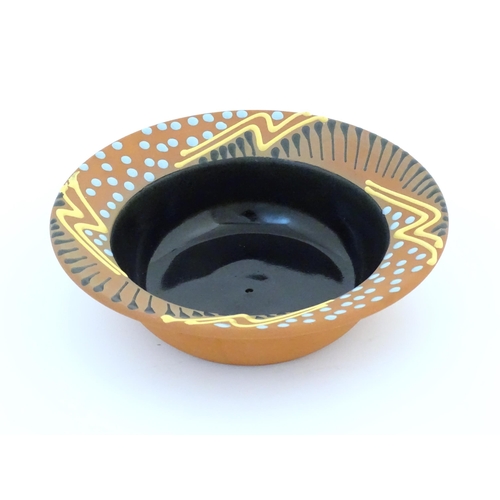 82 - An Australian studio pottery terracotta bowl by John Clift (b. 1954) with slip detail to rim. Signed... 