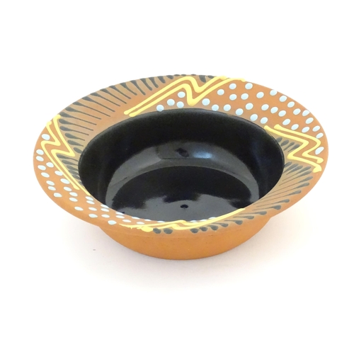 82 - An Australian studio pottery terracotta bowl by John Clift (b. 1954) with slip detail to rim. Signed... 