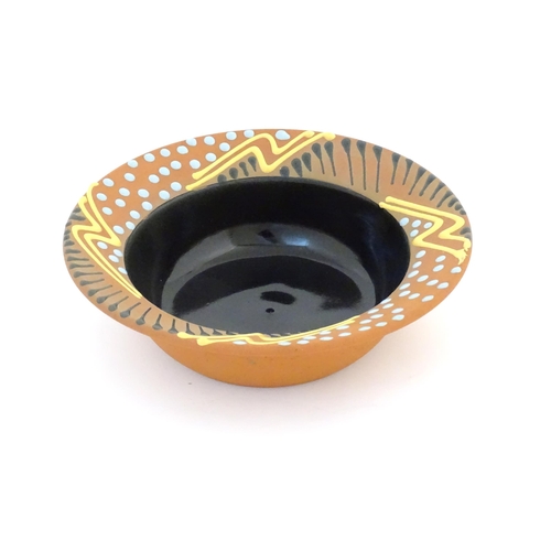 82 - An Australian studio pottery terracotta bowl by John Clift (b. 1954) with slip detail to rim. Signed... 