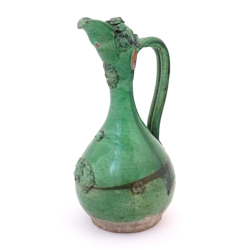 88 - A Turkish Canakkale pottery jug / ewer with a green glaze. Approx. 14