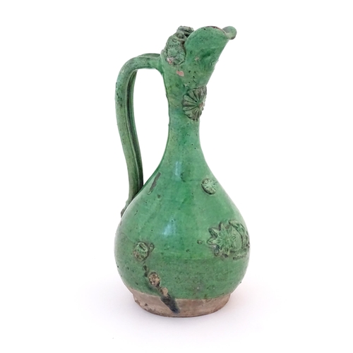 88 - A Turkish Canakkale pottery jug / ewer with a green glaze. Approx. 14