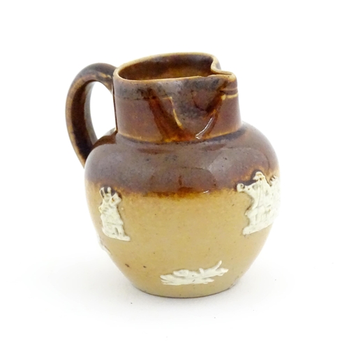 102 - A miniature Doulton Lambeth two tone stoneware jug with relief hunting decoration. Marked under. App... 