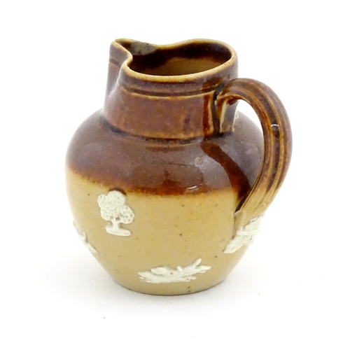 102 - A miniature Doulton Lambeth two tone stoneware jug with relief hunting decoration. Marked under. App... 