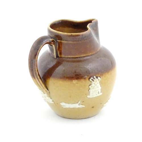 102 - A miniature Doulton Lambeth two tone stoneware jug with relief hunting decoration. Marked under. App... 