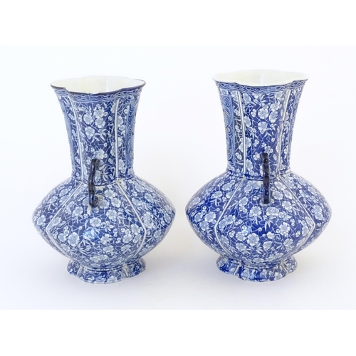 97 - A pair of Continental blue and white twin handled vases with floral / blossom decoration, the neck w... 