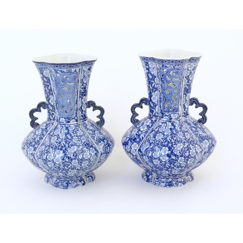 97 - A pair of Continental blue and white twin handled vases with floral / blossom decoration, the neck w... 