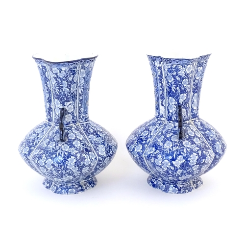 97 - A pair of Continental blue and white twin handled vases with floral / blossom decoration, the neck w... 