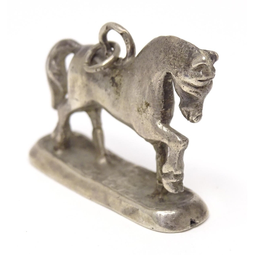 667 - A silver fob / pendant charm modelled as a horse. Approx 3/4
