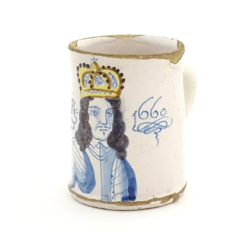 A tin glazed commemorative mug with polychrome decoration depicting a bust length portrait of King Charles II, crowned and wearing armour and titled 'CD2 and 1660'. Approx. 3 3/4" high, top diameter approx. 2 3/4", bottom diameter approx. 2 7/8"