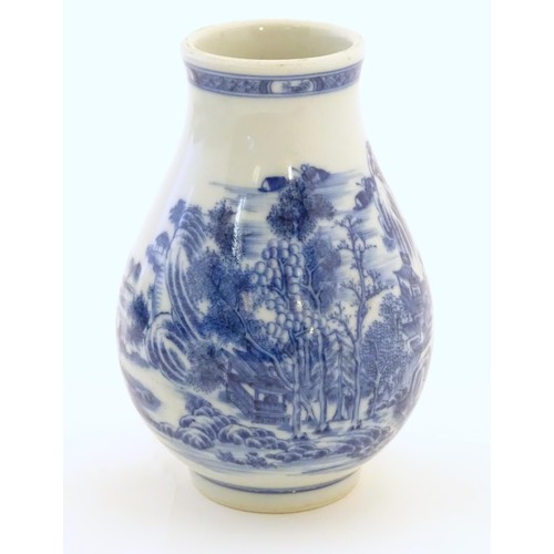 4 - A Chinese blue and white vase decorated with a landscape scene with mountains, pagodas, figures in b... 