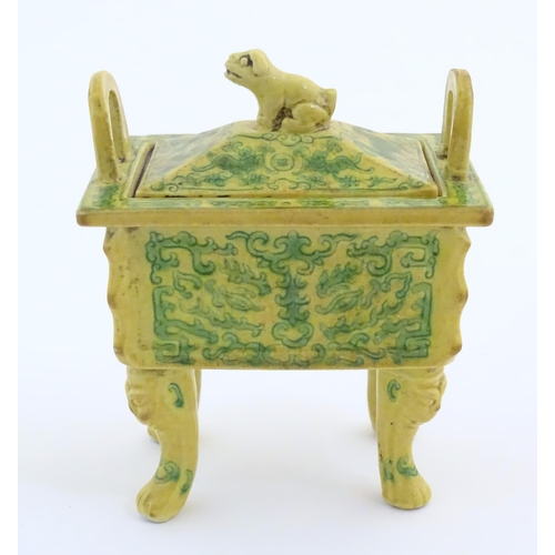 10 - A Chinese rectangular censer with a yellow ground, raised on 4 paw footed legs, with twin upright ha... 