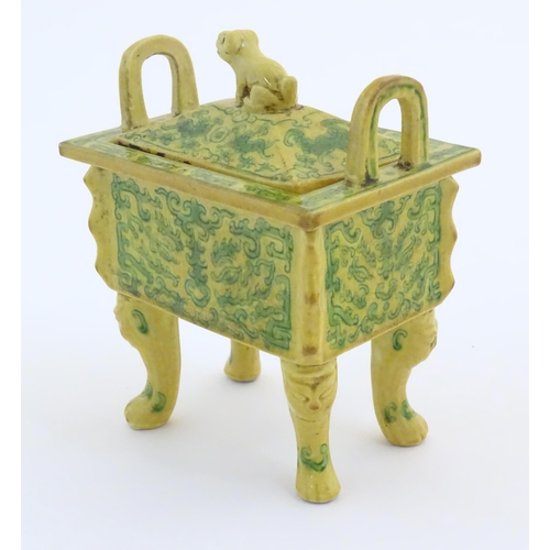 10 - A Chinese rectangular censer with a yellow ground, raised on 4 paw footed legs, with twin upright ha... 
