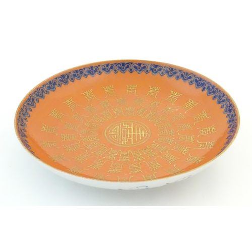 18 - A Chinese plate with an orange ground and gilt decoration with a blue border. The reverse decorated ... 