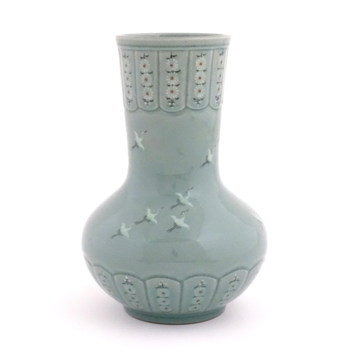 31 - An Oriental celadon glazed vase decorated with crane birds and flowers. Character marks under. Appro... 