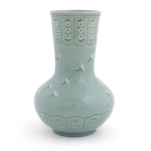 31 - An Oriental celadon glazed vase decorated with crane birds and flowers. Character marks under. Appro... 