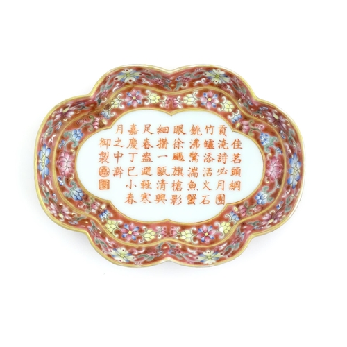 32 - A Chinese dish of shaped form with a pink ground decorated with Character script bordered by flowers... 