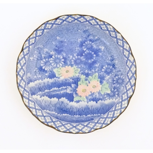 43 - An Oriental blue and white plate with pink and green highlights depicting flowers. Character marks u... 