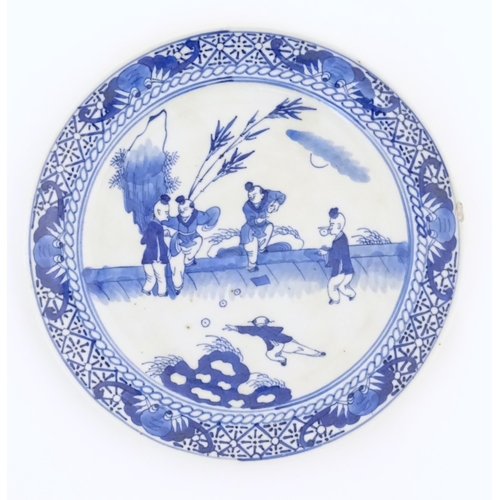 44 - A Chinese blue and white plate decorated with figures in a garden landscape with apples. Approx. 8 1... 