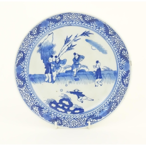 44 - A Chinese blue and white plate decorated with figures in a garden landscape with apples. Approx. 8 1... 