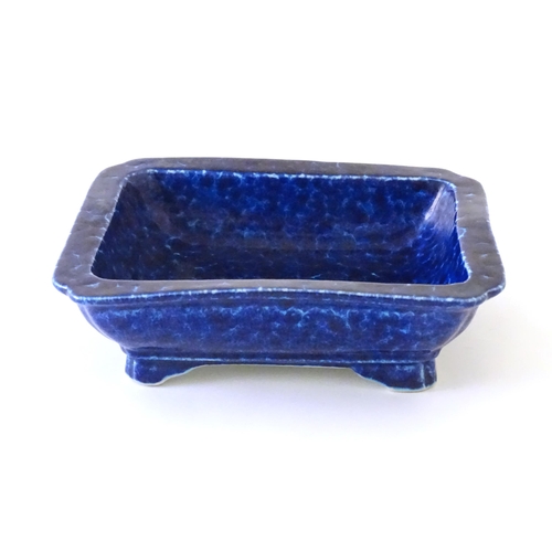 46 - A Chinese dish of rectangular form with a blue glaze, raised on four feet. Character marks under. Ap... 