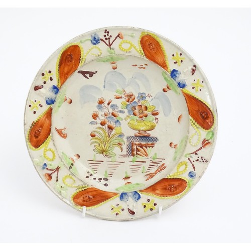 60 - A 19thC plate decorated in Pratt colours depicting flowers and foliage. Approx. 8 3/4