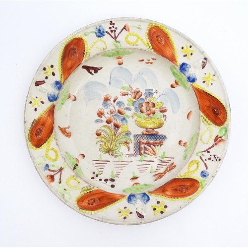 60 - A 19thC plate decorated in Pratt colours depicting flowers and foliage. Approx. 8 3/4