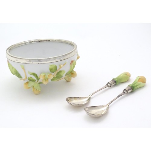 124 - A 20thC Continental ceramic salad bowl with a silver plate rim, the bowl with relief leaf and cob nu... 