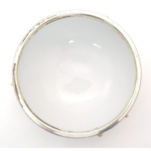 124 - A 20thC Continental ceramic salad bowl with a silver plate rim, the bowl with relief leaf and cob nu... 