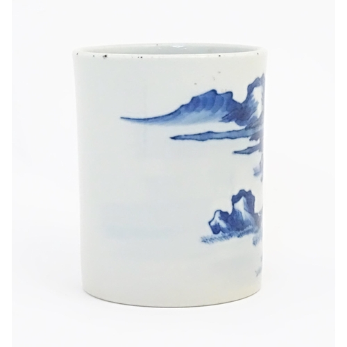 24 - A Chinese blue and white brush pot of cylindrical form decorated with a mountain landscape. Approx. ... 