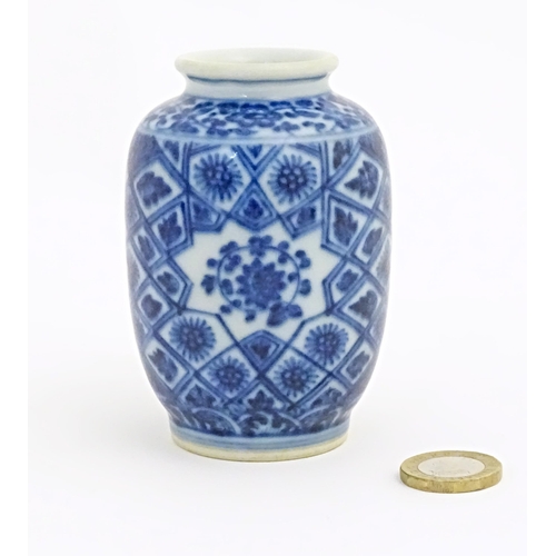 26 - A small Chinese blue and white vase decorated with flowers and foliage in a geometric framework. Cha... 