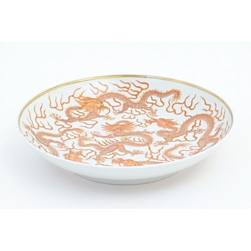 35 - A Chinese plate decorated with five dragons amongst stylised clouds with a gilt flaming pearl. Chara... 