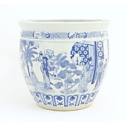 36 - An Oriental style blue and white planter / jardiniere decorated with female figures in a garden land... 