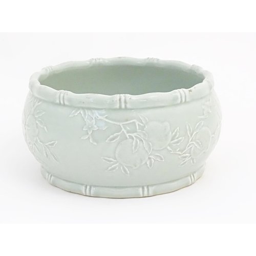 41 - A Chinese celadon bowl decorated in relief with bats and peaches. Character marks under. Approx. 5