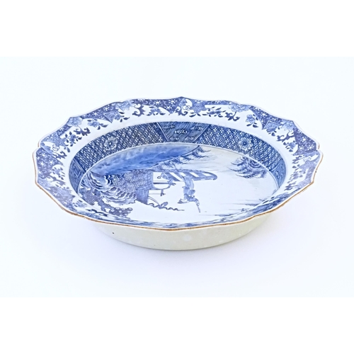 7 - A Chinese blue and white bowl with shaped rim, decorated with a coastal scene with a figure and a st... 