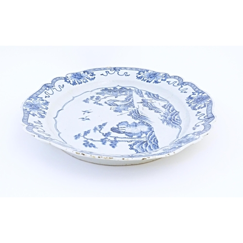 8 - A Chinese blue and white plate of oval form with a shaped rim, decorated with a figure in a rocky la... 