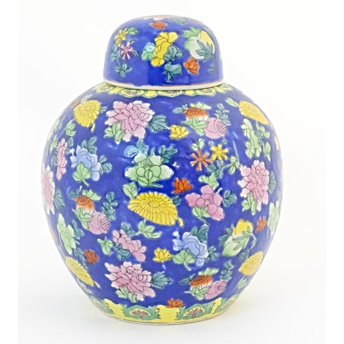 52 - A Chinese ginger jar with a blue ground decorated with flowers and foliage. Approx. 10 1/4
