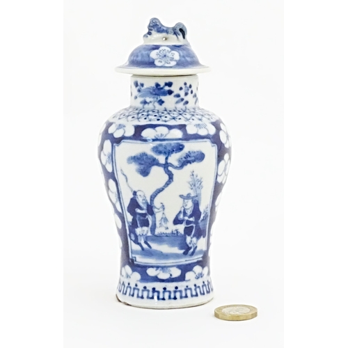 55 - A Chinese blue and white vase and cover with panelled decoration depicting figures in a landscape bo... 