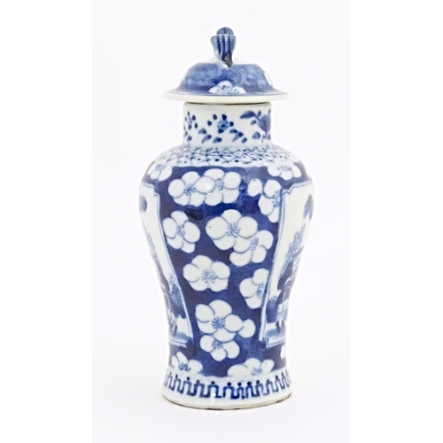 55 - A Chinese blue and white vase and cover with panelled decoration depicting figures in a landscape bo... 