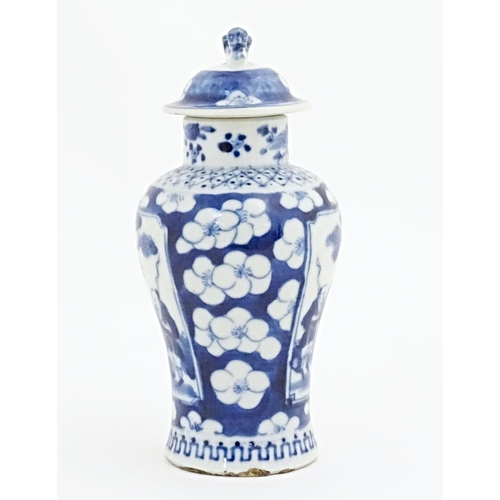 55 - A Chinese blue and white vase and cover with panelled decoration depicting figures in a landscape bo... 