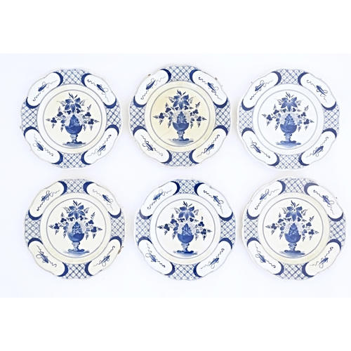 59 - Six blue and white Delft plates decorated with a central bouquet of flowers in a vase, with a patter... 