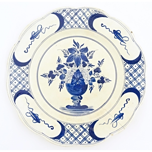 59 - Six blue and white Delft plates decorated with a central bouquet of flowers in a vase, with a patter... 