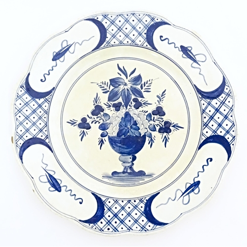 59 - Six blue and white Delft plates decorated with a central bouquet of flowers in a vase, with a patter... 