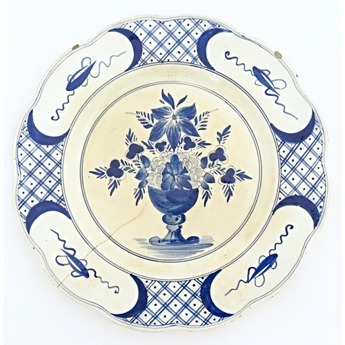 59 - Six blue and white Delft plates decorated with a central bouquet of flowers in a vase, with a patter... 