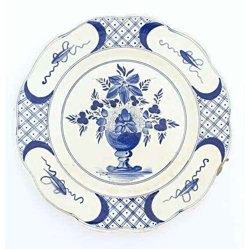 59 - Six blue and white Delft plates decorated with a central bouquet of flowers in a vase, with a patter... 