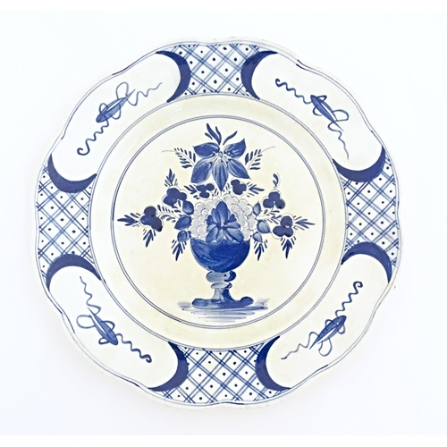 59 - Six blue and white Delft plates decorated with a central bouquet of flowers in a vase, with a patter... 